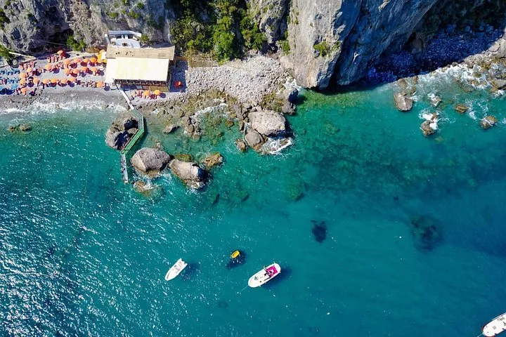 A luxury private boat anchored in a bay with swimmers on a private boat tour of the Amalfi Coast, Italy