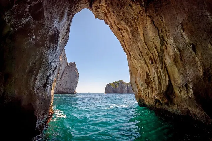 A private boat passing the Faraglioni rocks off Capri on a private boat tour of the Amalfi Coast, Italy